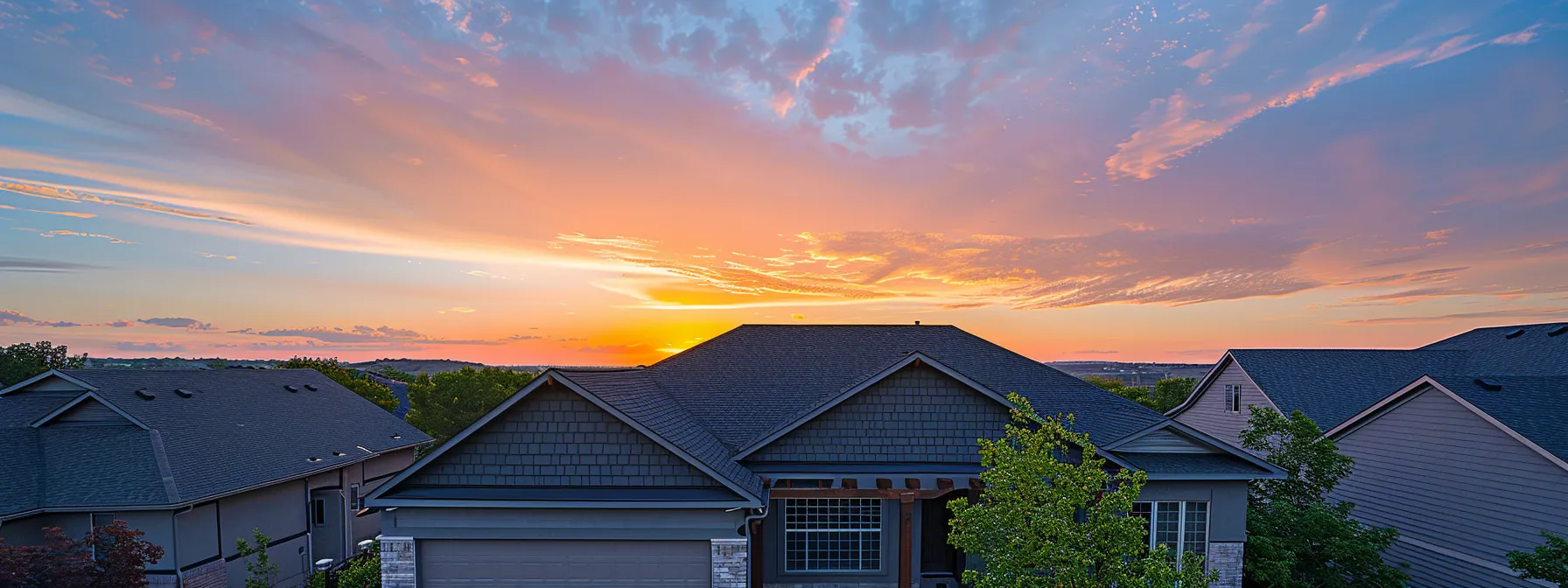 a radiant sunset highlighting a pristine roof coated in a glossy finish, reflecting true grit's impeccable craftsmanship and roofing expertise in olathe.