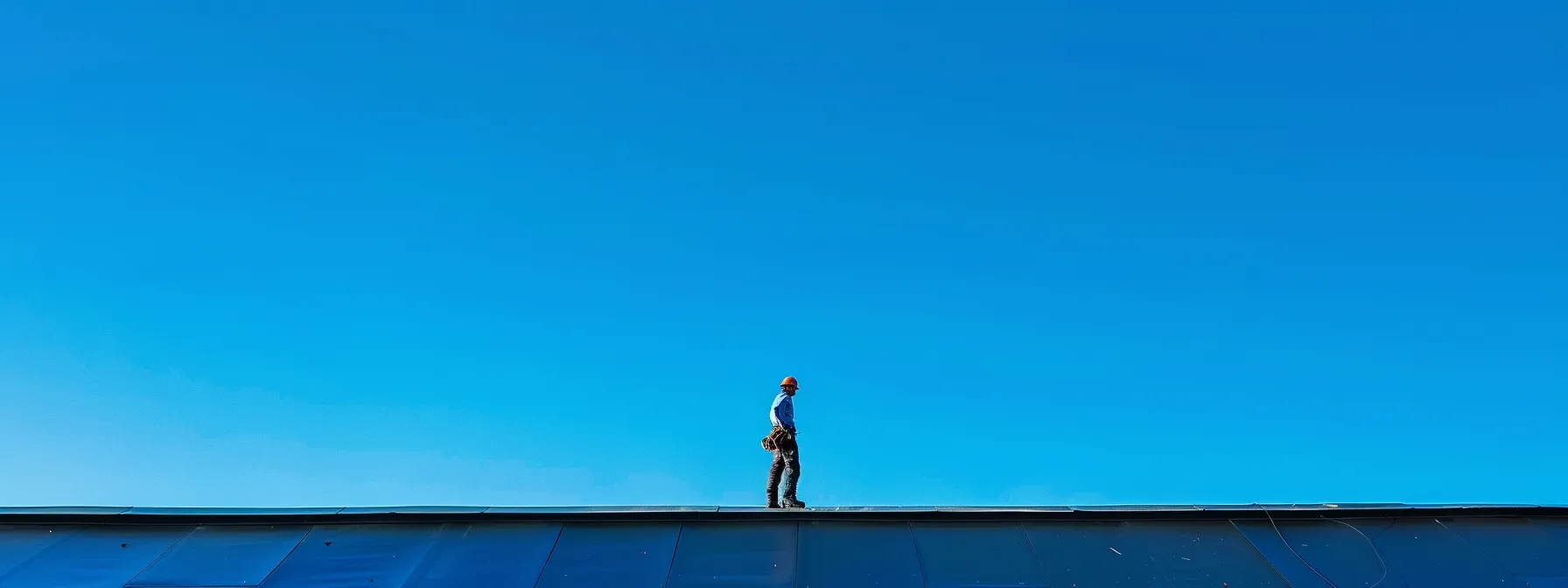 a skilled roofer meticulously installing a waterproof bitumen roof under a clear blue sky in olathe.